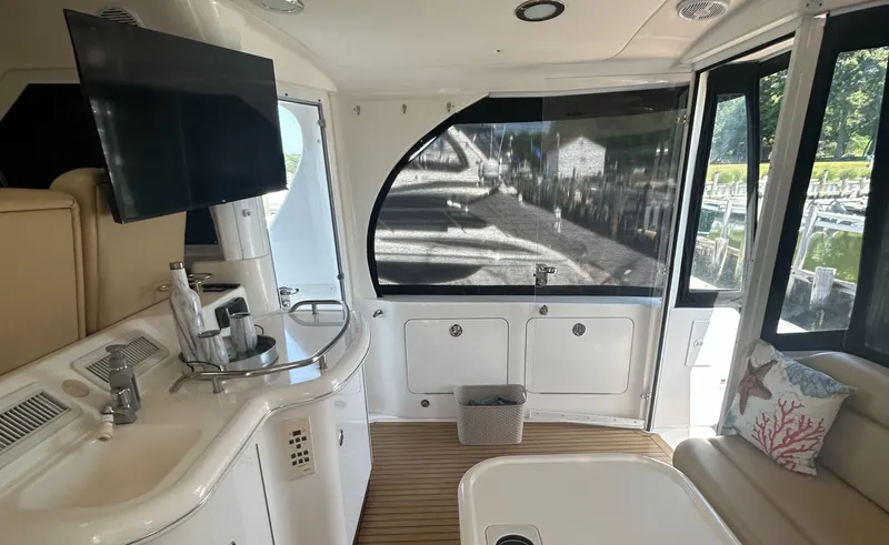 Slide: The Image of Interior of 2002 Sea Ray 480 Motor Yacht with TV, seating, and kitchenette. - 9