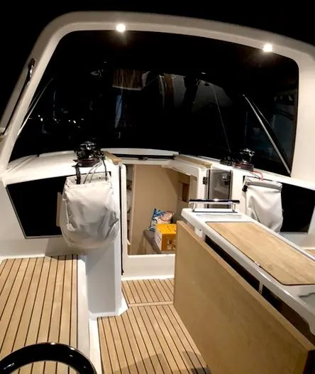 Slide: The Image of 2022 Beneteau Oceanis 38.1 yacht cockpit with wood flooring and storage compartments. - 10
