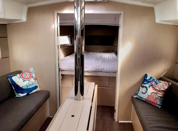 Slide: The Image of Interior of 2022 Beneteau Oceanis 38.1 yacht, featuring cozy seating and a comfortable bed. - 14