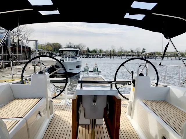 Slide: The Image of 2022 Beneteau Oceanis 38.1 yacht cockpit with dual steering wheels, docked at marina. - 6