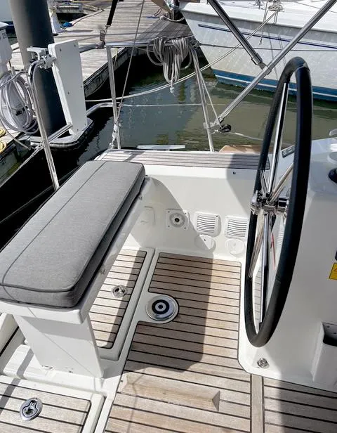 Slide: The Image of Cockpit of 2022 Beneteau Oceanis 38.1 sailboat with steering wheel and seating. - 7