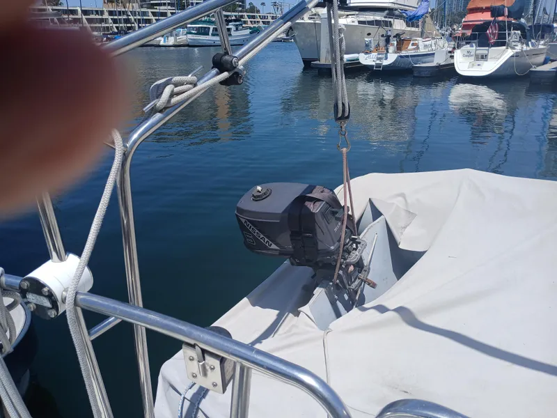 Slide: The Image of 1984 Newport Sailboat with Nissan outboard motor docked in marina. - 10
