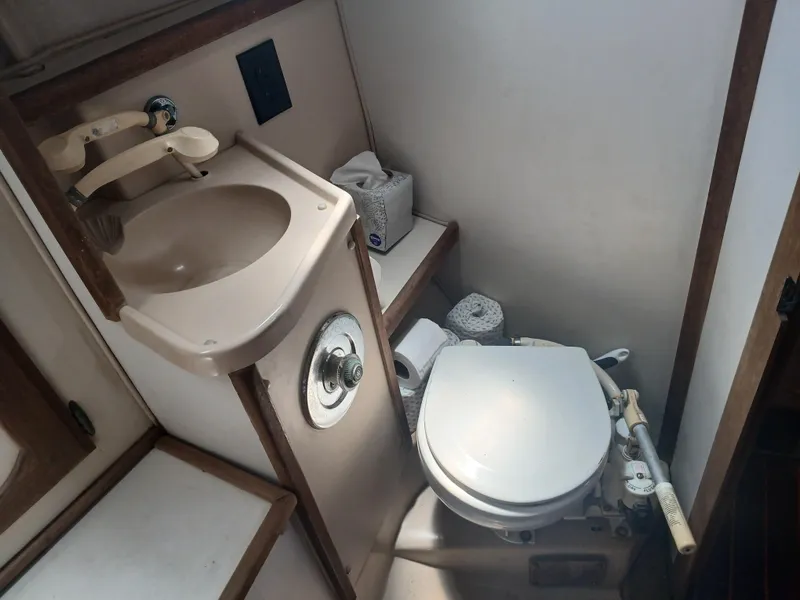 Slide: The Image of Compact bathroom in a 1984 Newport Sailboat with sink and marine toilet. - 14