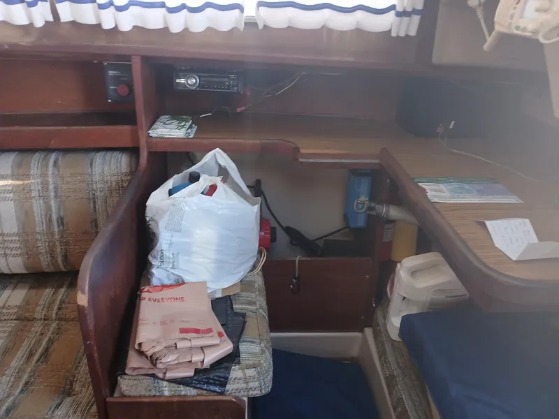 Slide: The Image of Interior of a 1984 Newport Sailboat with seating, storage, and nautical equipment. - 16
