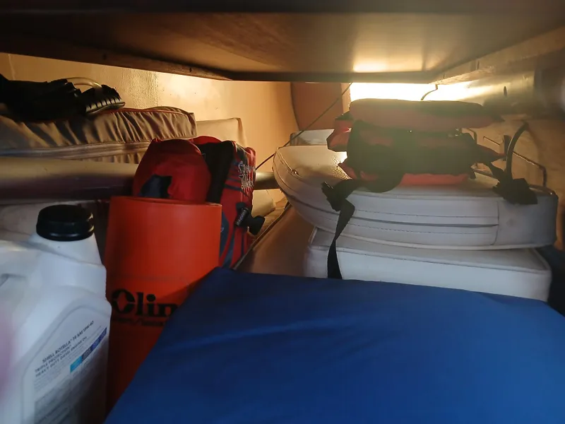 Slide: The Image of Storage compartment in a 1984 Newport Sailboat with life jackets and supplies. - 17