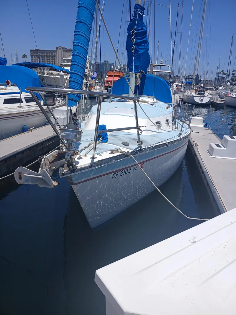 Slide: The Image of 1984 Newport Sailboat docked in marina, featuring blue sails and calm waters. - 2