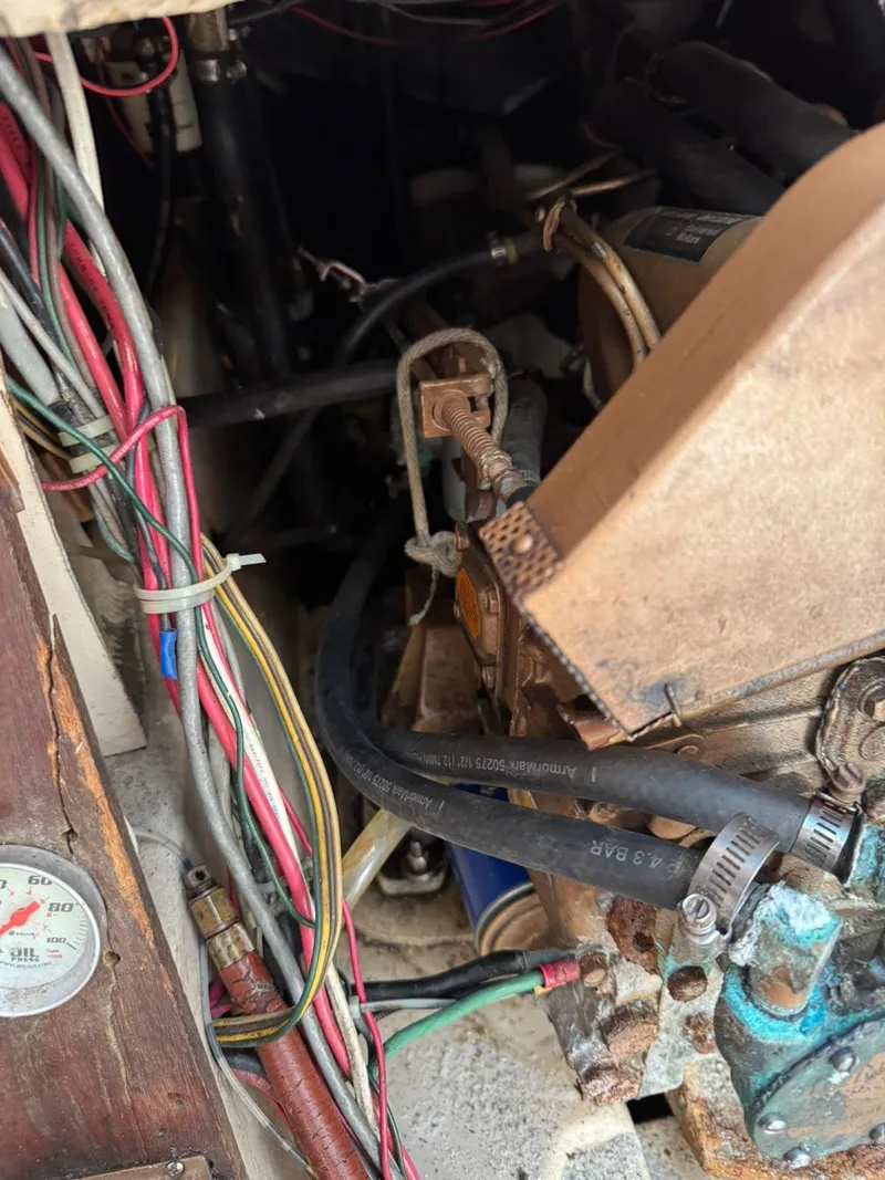 Slide: The Image of Engine compartment of a 1984 Newport Sailboat with visible wiring and hoses. - 21