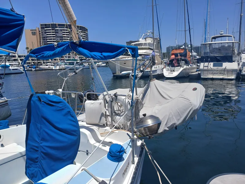 Slide: The Image of 1984 Newport Sailboat docked in marina, surrounded by other boats under clear blue sky. - 4