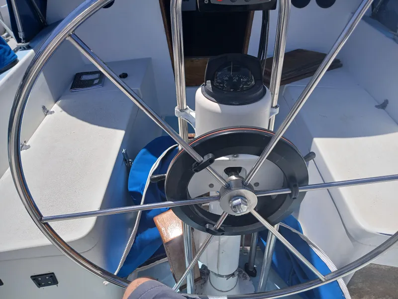 Slide: The Image of Steering wheel of a 1984 Newport Sailboat, featuring a compass and cockpit view. - 9