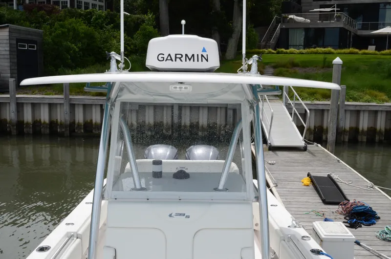 Slide: The Image of 2017 Contender 28 Sport boat docked, featuring Garmin equipment, surrounded by lush greenery. - 13
