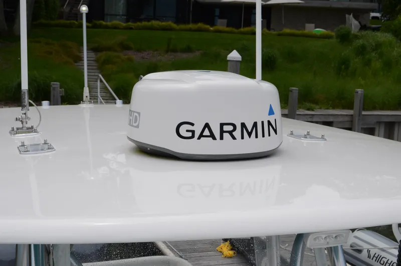 Slide: The Image of Garmin radar on 2017 Contender 28 Sport boat, docked with green landscape background. - 14