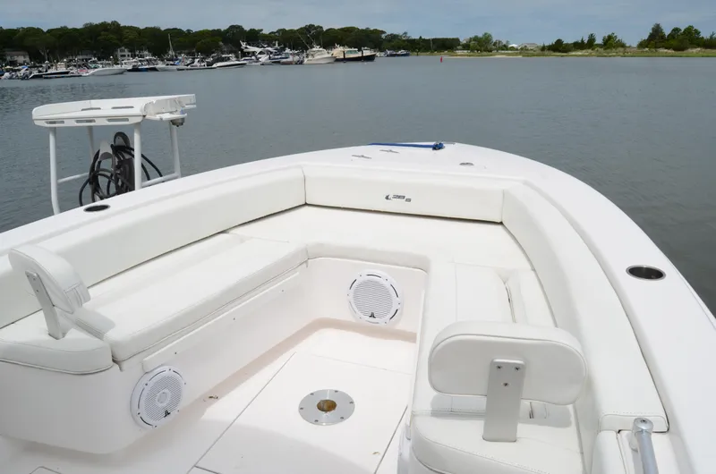 Slide: The Image of 2017 Contender 28 Sport boat with white seating, docked in a calm marina. - 17