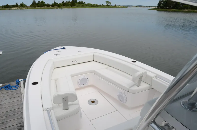 Slide: The Image of 2017 Contender 28 Sport boat with white seating, docked by calm waters. - 18
