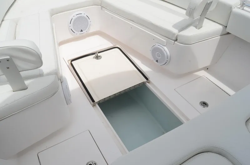 Slide: The Image of 2017 Contender 28 Sport boat interior with open storage compartment and white seating. - 19