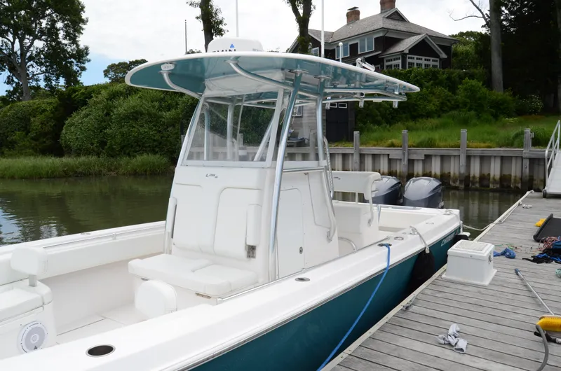 Slide: The Image of 2017 Contender 28 Sport boat docked by a wooden pier, surrounded by lush greenery. - 6