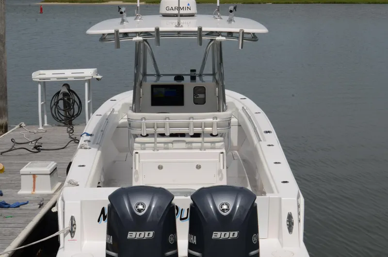 Slide: The Image of 2017 Contender 28 Sport boat with dual Yamaha engines docked by the water. - 7