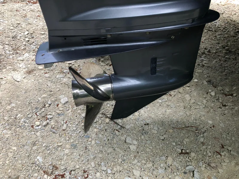 Slide: The Image of Close-up of a 2015 Parker 2530 Extended Cabin boat propeller on gravel. - 15