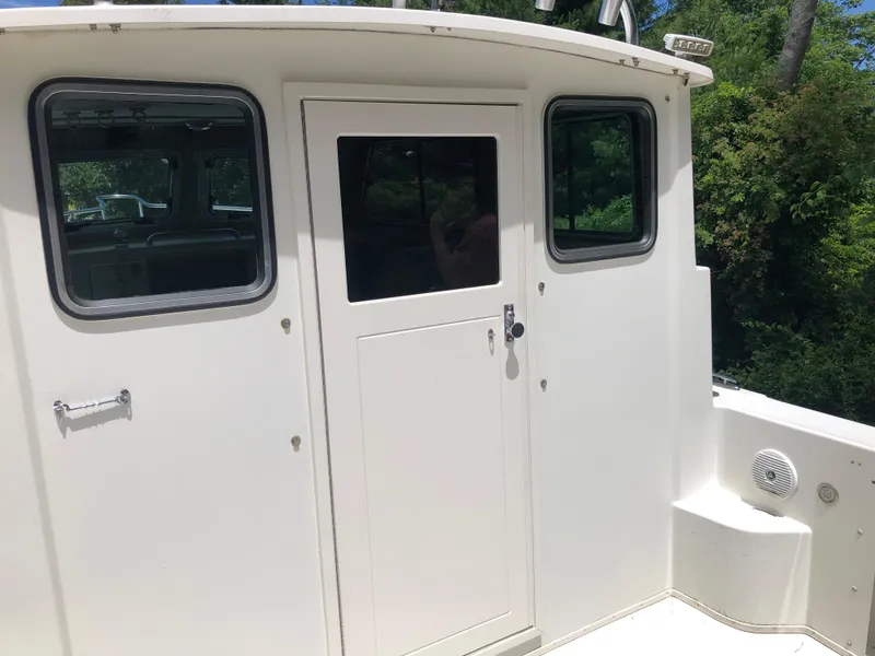 Slide: The Image of 2015 Parker 2530 Extended Cabin boat exterior with windows and door. - 4