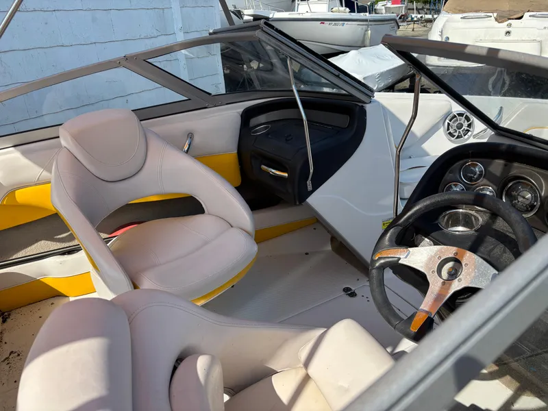 Slide: The Image of Interior of a 2012 Crownline 185 SS boat with white and yellow seating. - 11