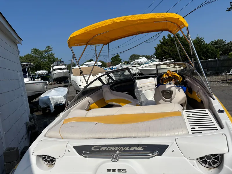 Slide: The Image of 2012 Crownline 185 SS boat with yellow canopy, parked in a marina. - 7