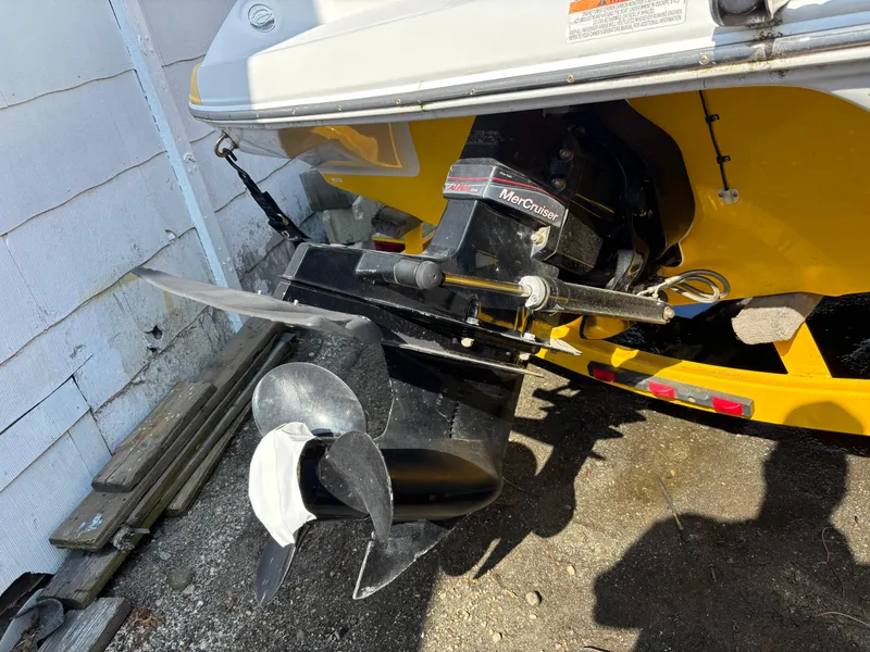 Slide: The Image of 2012 Crownline 185 SS boat with MerCruiser outdrive, parked on gravel. - 8