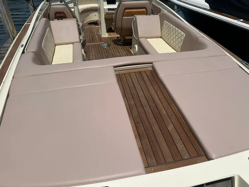 Slide: The Image of 2019 Chris-Craft Launch 30 boat interior with beige seating and wooden deck. - 11