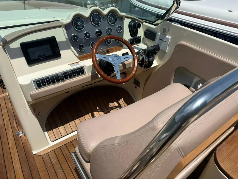 Slide: The Image of 2019 Chris-Craft Launch 30 boat cockpit with wooden steering wheel and dashboard controls. - 15