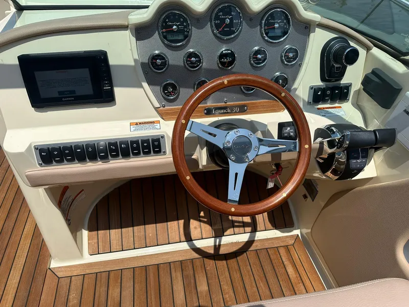 Slide: The Image of 2019 Chris-Craft Launch 30 dashboard with wooden steering wheel and modern controls. - 17