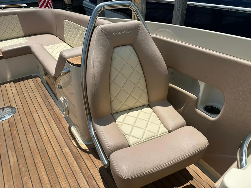 Slide: The Image of 2019 Chris-Craft Launch 30 boat interior with beige leather seating and wooden deck. - 25