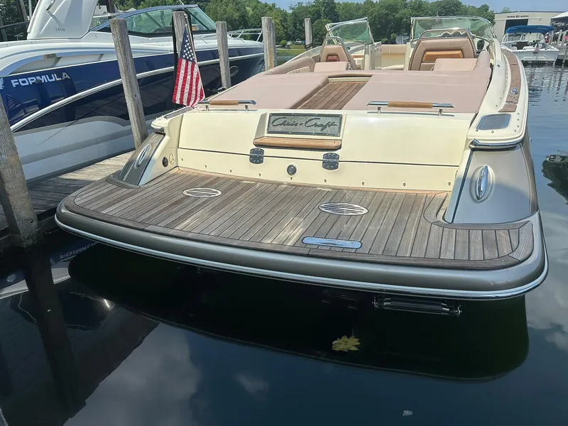 Slide: The Image of 2019 Chris-Craft Launch 30 boat docked, featuring elegant wood deck and American flag. - 9