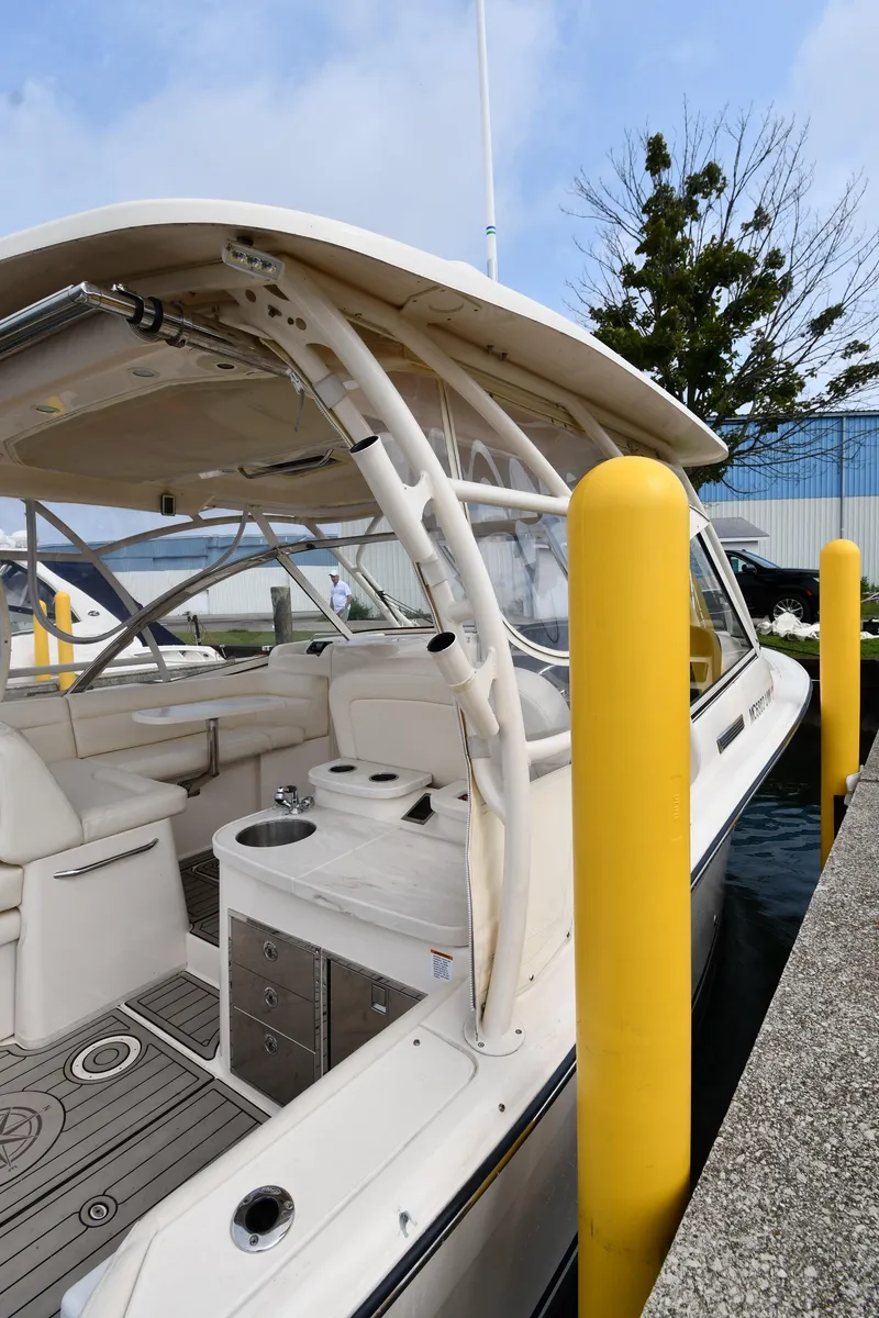 Slide: The Image of 2018 Grady-White Freedom 335 boat docked, showcasing spacious seating and sleek design. - 2