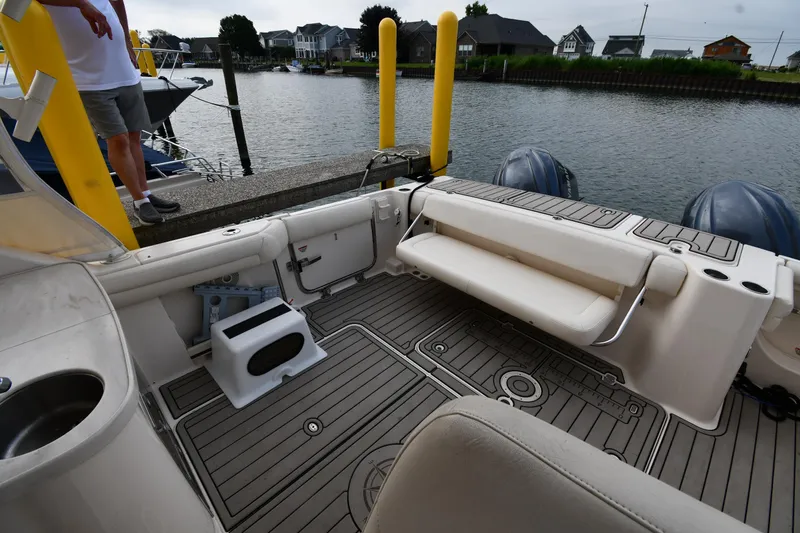 Slide: The Image of 2018 Grady-White Freedom 335 boat interior at dock, featuring seating and dual engines. - 26
