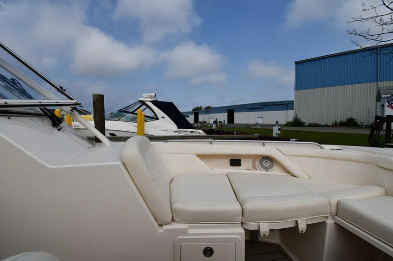Slide: The Image of 2018 Grady-White Freedom 335 boat interior with white seating, docked near blue warehouse. - 37