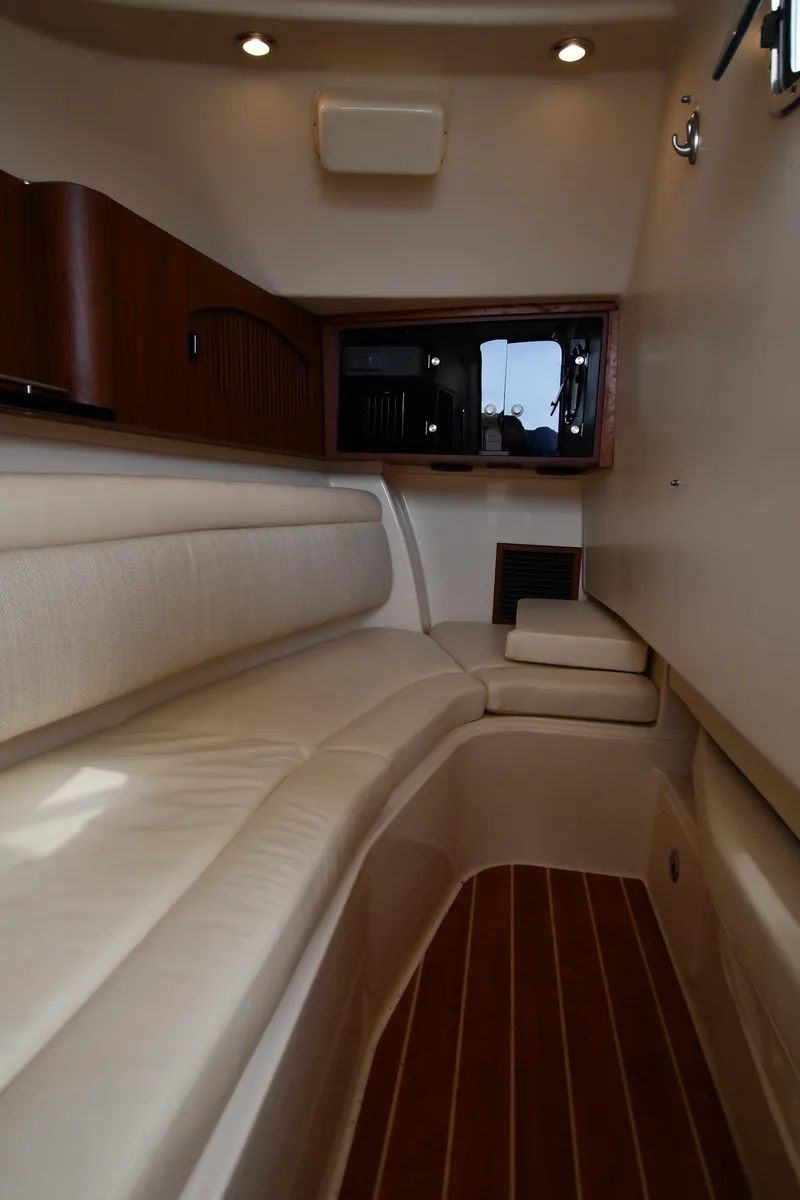 Slide: The Image of 2018 Grady-White Freedom 335 cabin interior with cushioned seating and wood accents. - 48