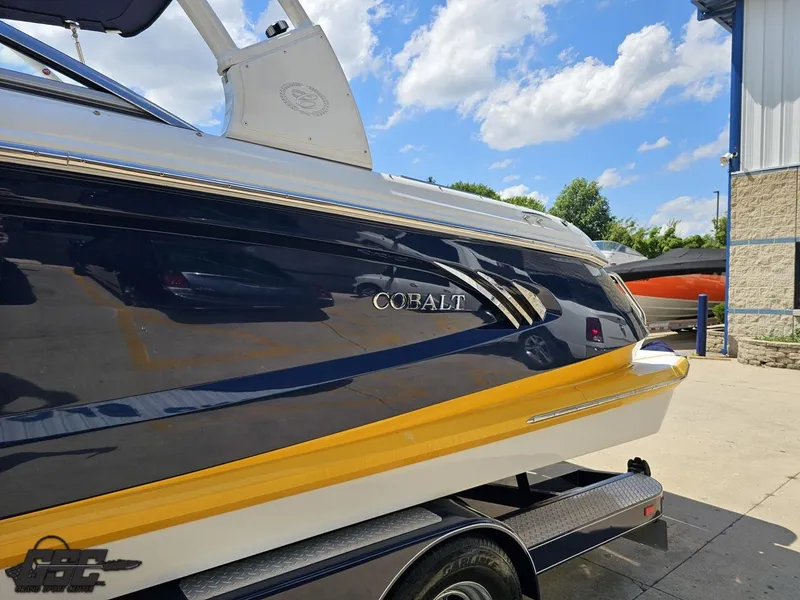 Slide: The Image of 2015 Cobalt A28 boat with sleek design, parked outdoors under a blue sky. - 17