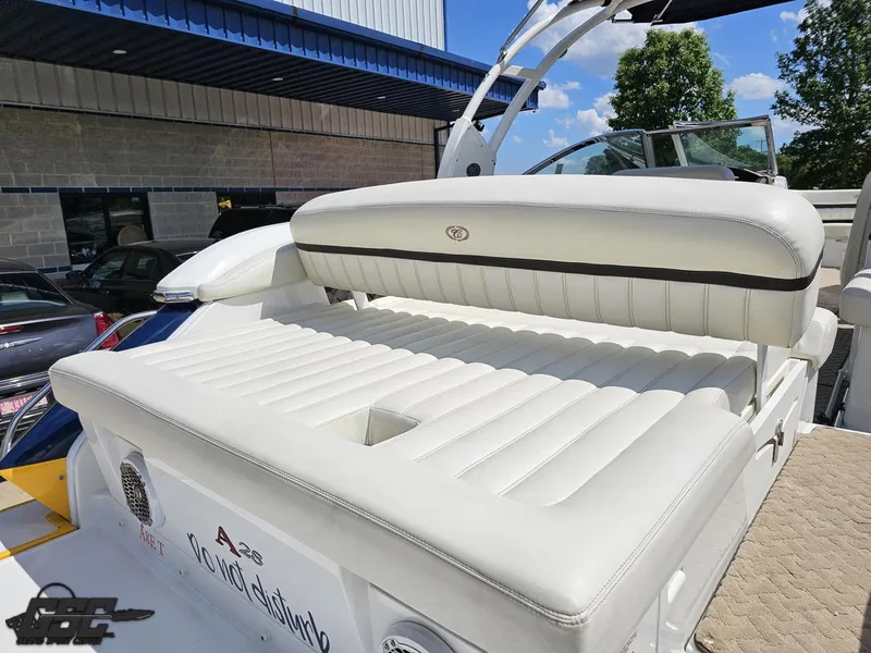 Slide: The Image of 2015 Cobalt A28 boat with white leather seating, docked outdoors under a blue sky. - 31