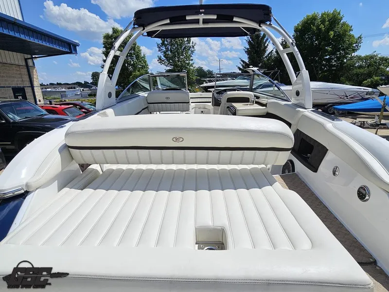 Slide: The Image of 2015 Cobalt A28 boat with white leather seating, docked outdoors under a blue sky. - 32