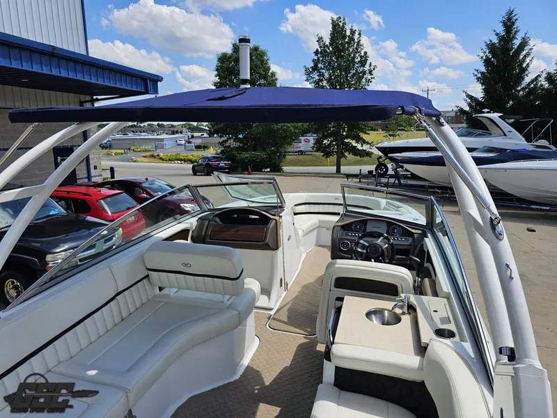 Slide: The Image of 2015 Cobalt A28 boat interior with white seating, steering wheel, and canopy. - 36