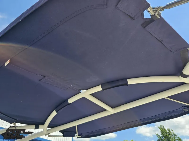 Slide: The Image of 2015 Cobalt A28 boat canopy, blue fabric with metal frame, under clear sky. - 37