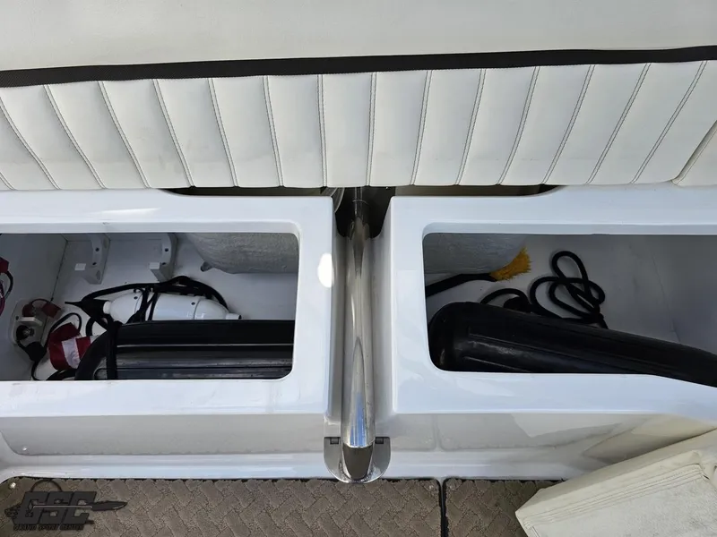 Slide: The Image of 2015 Cobalt A28 boat storage compartments with white cushioned seating and equipment. - 46