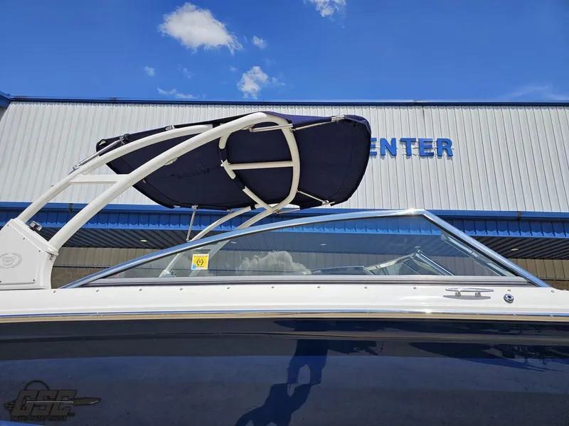 Slide: The Image of 2015 Cobalt A28 boat with canopy, parked outside a building under a clear blue sky. - 5