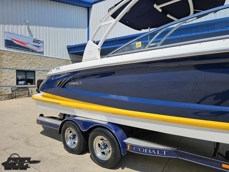 Slide: The Image of 2015 Cobalt A28 boat on trailer outside a building, showcasing sleek design and vibrant colors. - 6