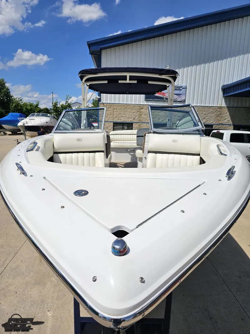 Slide: The Image of 2015 Cobalt A28 boat with white interior, parked outdoors under a clear blue sky. - 9
