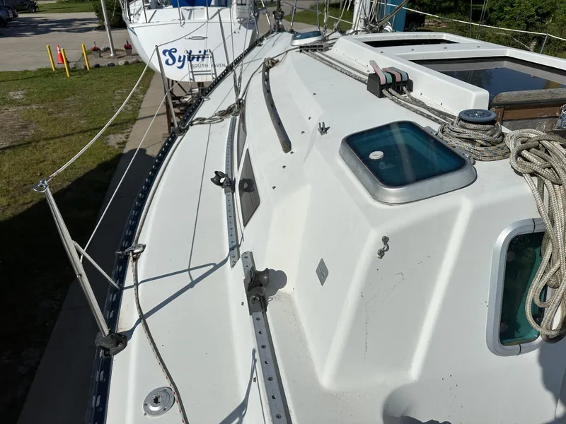 Slide: The Image of 1989 C&C 30 sailboat deck with ropes and hatch, docked outdoors. - 18