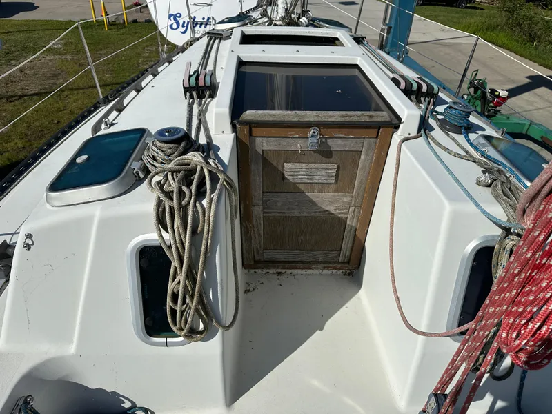 Slide: The Image of 1989 C&C 30 sailboat deck with ropes and wooden hatch. - 19
