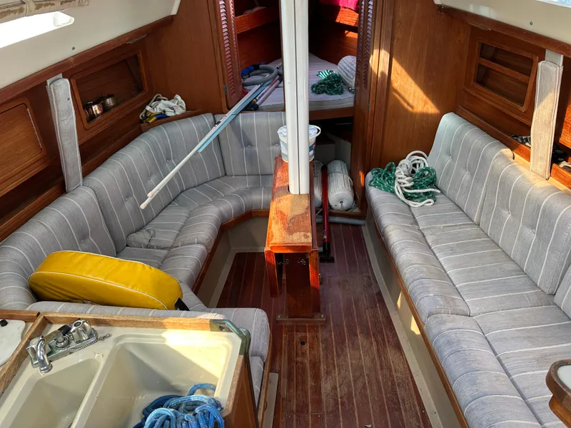 Slide: The Image of Interior of 1989 C&C 30 sailboat with striped seating and wooden accents. - 24
