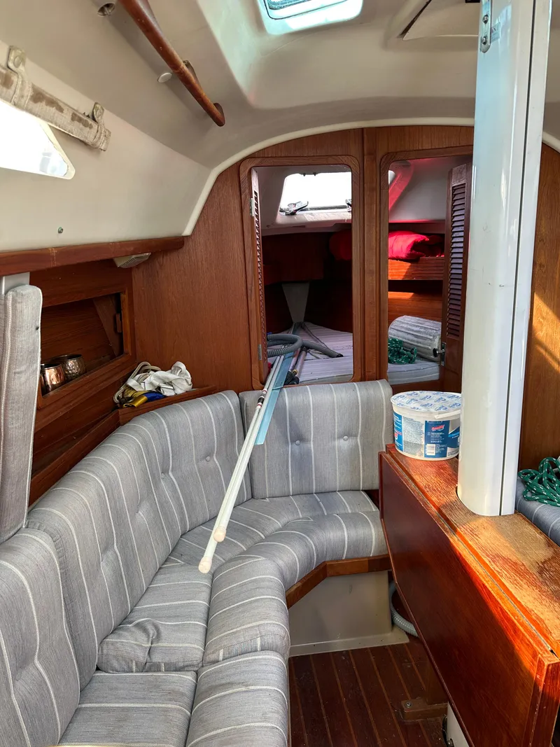 Slide: The Image of Interior of a 1989 C&C 30 sailboat with striped seating and wooden accents. - 26