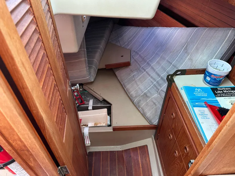 Slide: The Image of Interior of 1989 C&C 30 sailboat with chartbook, tools, and storage. - 28