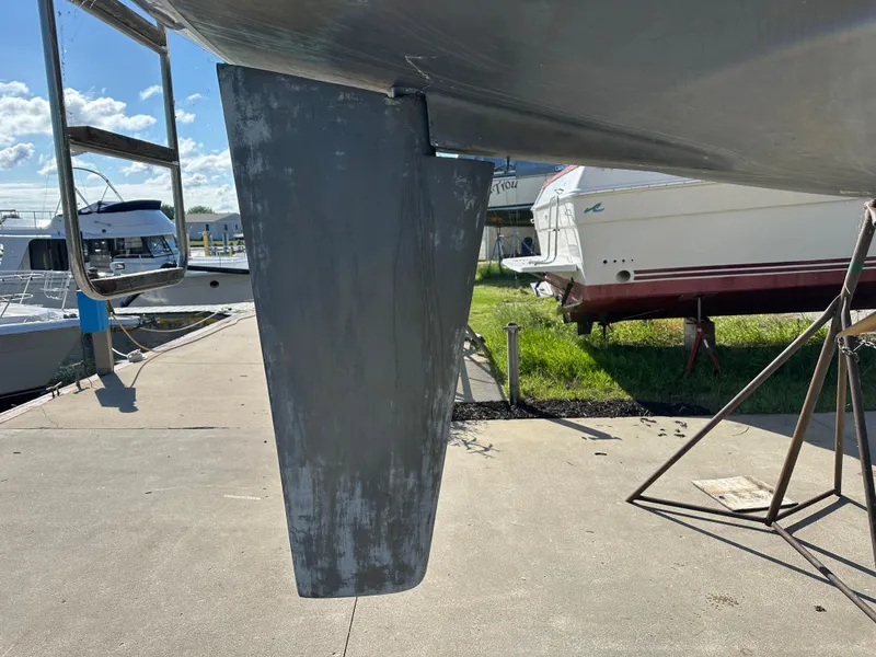 Slide: The Image of 1989 C&C 30 sailboat keel on dry dock, surrounded by other boats. - 8