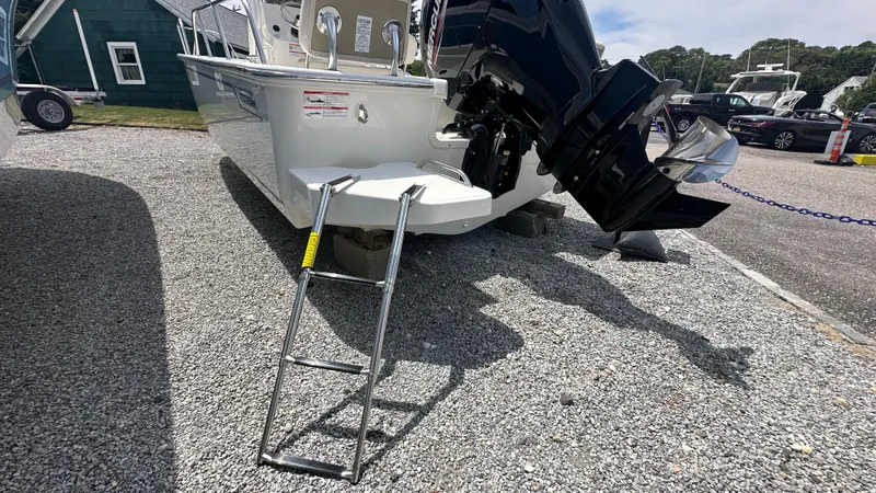 Slide: The Image of 2025 Boston Whaler 190 Montauk boat with ladder and outboard motor on gravel. - 4